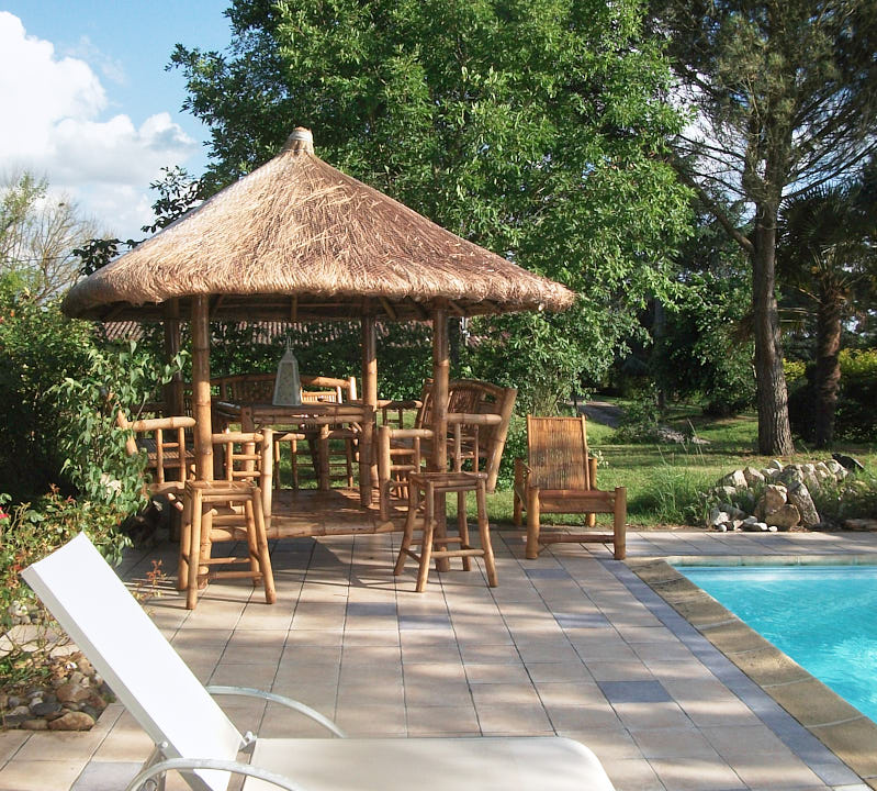 Paillote bambou de jardin, modèle Perrellos avec toit en chaume au bord d'une piscine